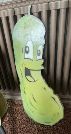 The Wooden Pickle painted by Airbrush Ron Hernandez, previously hung inside “The Mighty Pickle” that presently rides on the inside of the baggage door of “The Chief” at Marty Stuart’s Congress of Country Music Museum, Philadelphia, MI (2019) Wooden Pickle